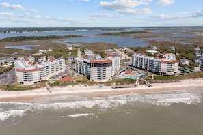 A coastal hotel with multiple buildings, a beach, and a view of the sea and marshy landscape. - St. Regis 3012- 3BR Oceanfront Condo in North Topsail Beach with Tennis Court, Elevator & Communi... (North Topsail)