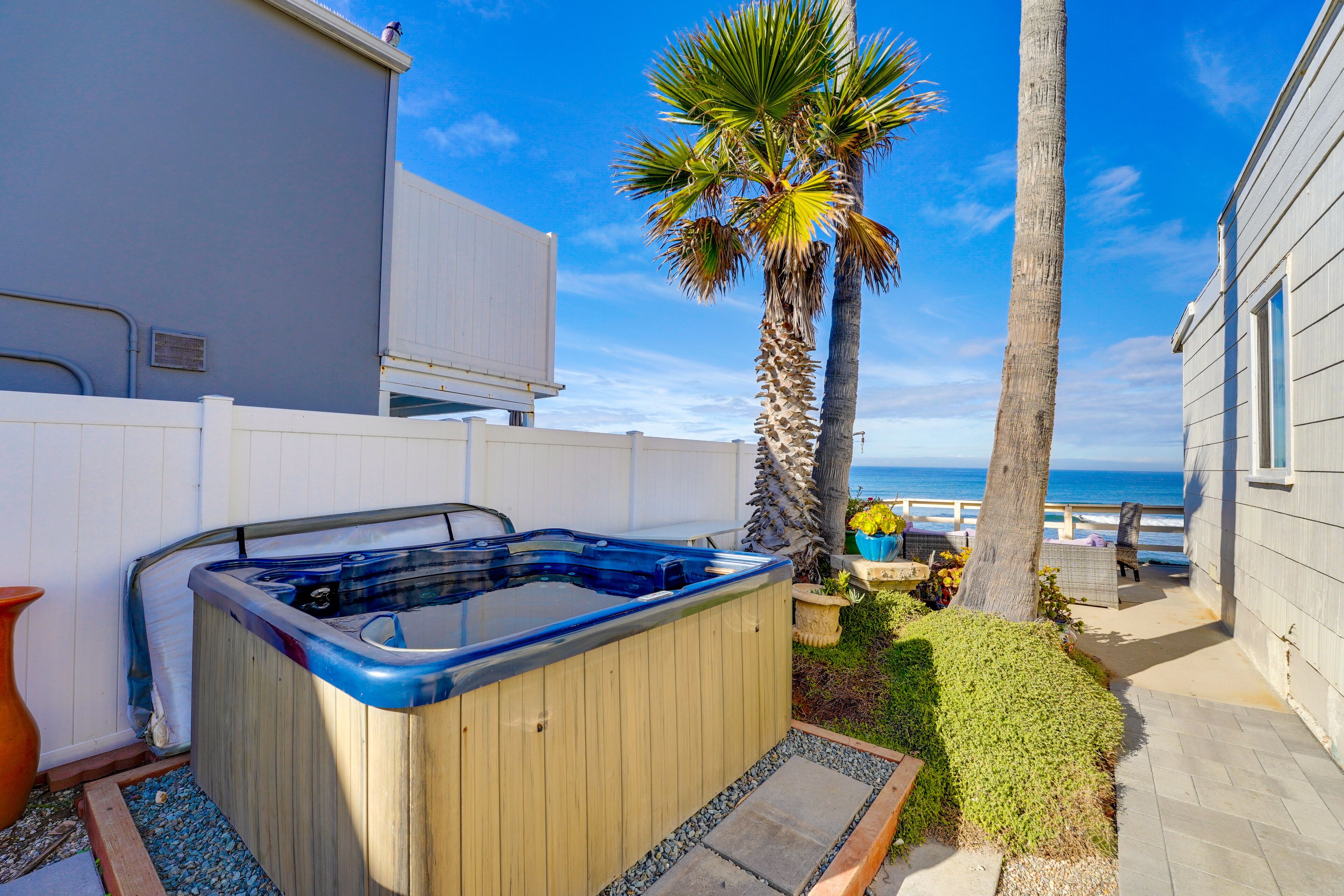 A hot tub in a backyard with a view of the ocean.