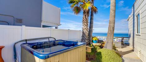 A hot tub in a backyard with a view of the ocean.