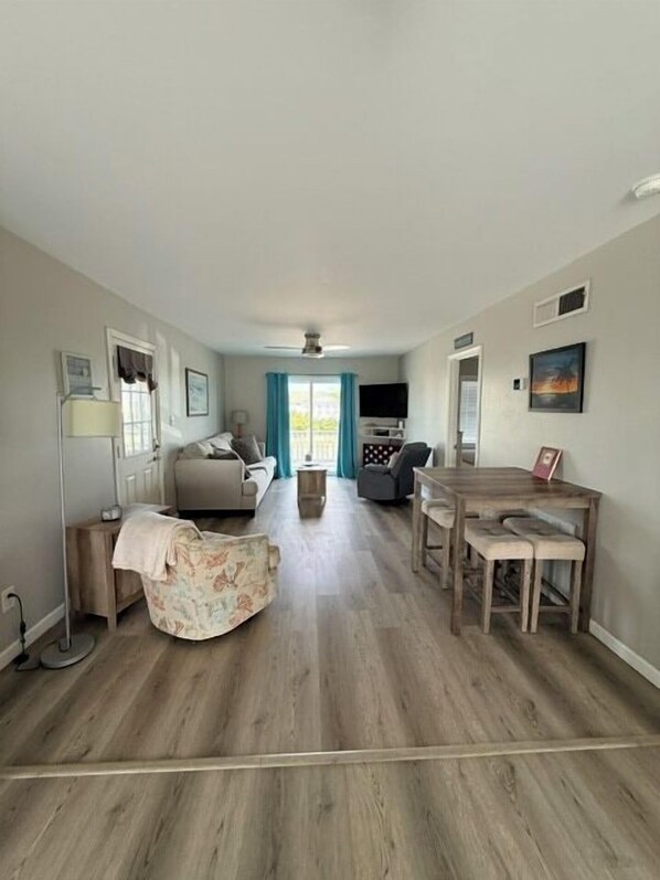 A spacious living area with a sofa, coffee table, and dining table.