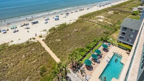 Blick auf den Strand vom Hotel aus, mit Swimmingpool und Außenbereich.
