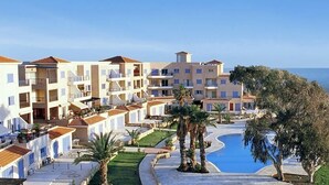 A resort with multiple buildings, a swimming pool, and a view of the sea. - Kings Palace - Modern Penthouse | Incredible Sea Views | Pool (Paphos)