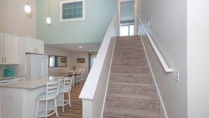 A kitchen with white cabinets, a granite countertop, and a teal coffee maker. - Beautiful Bayfront Townhouse located downtown Ocean City. Free WiFi, Elevator (Ocean City)