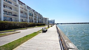 A waterfront walkway with a wooden deck, a row of white multi-story buildings, and a pier in the background. - Beautiful Bayfront Townhouse located downtown Ocean City. Free WiFi, Elevator (Ocean City)