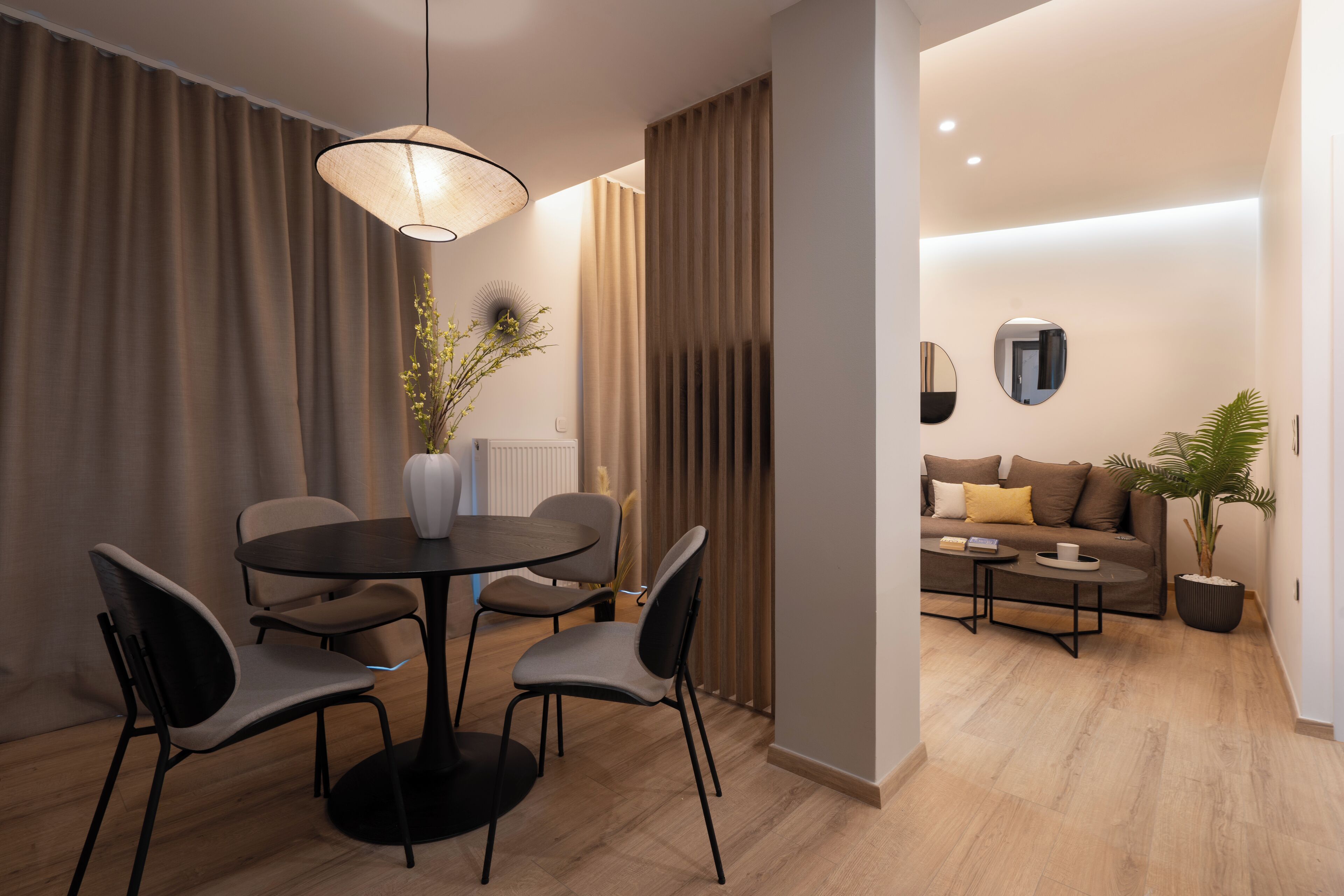 En moderne stue med sofa, sofabord og spiseplads med stole og bord.