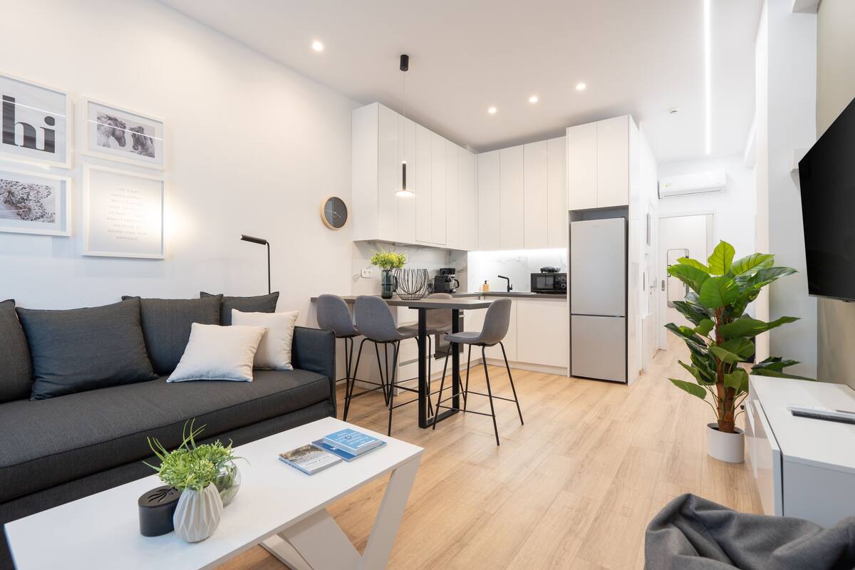 Un appartement moderne comprenant un espace de vie, une cuisine et un coin repas.
