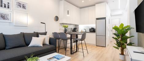 Een modern appartement met een woonkamer, keuken en een eethoek.