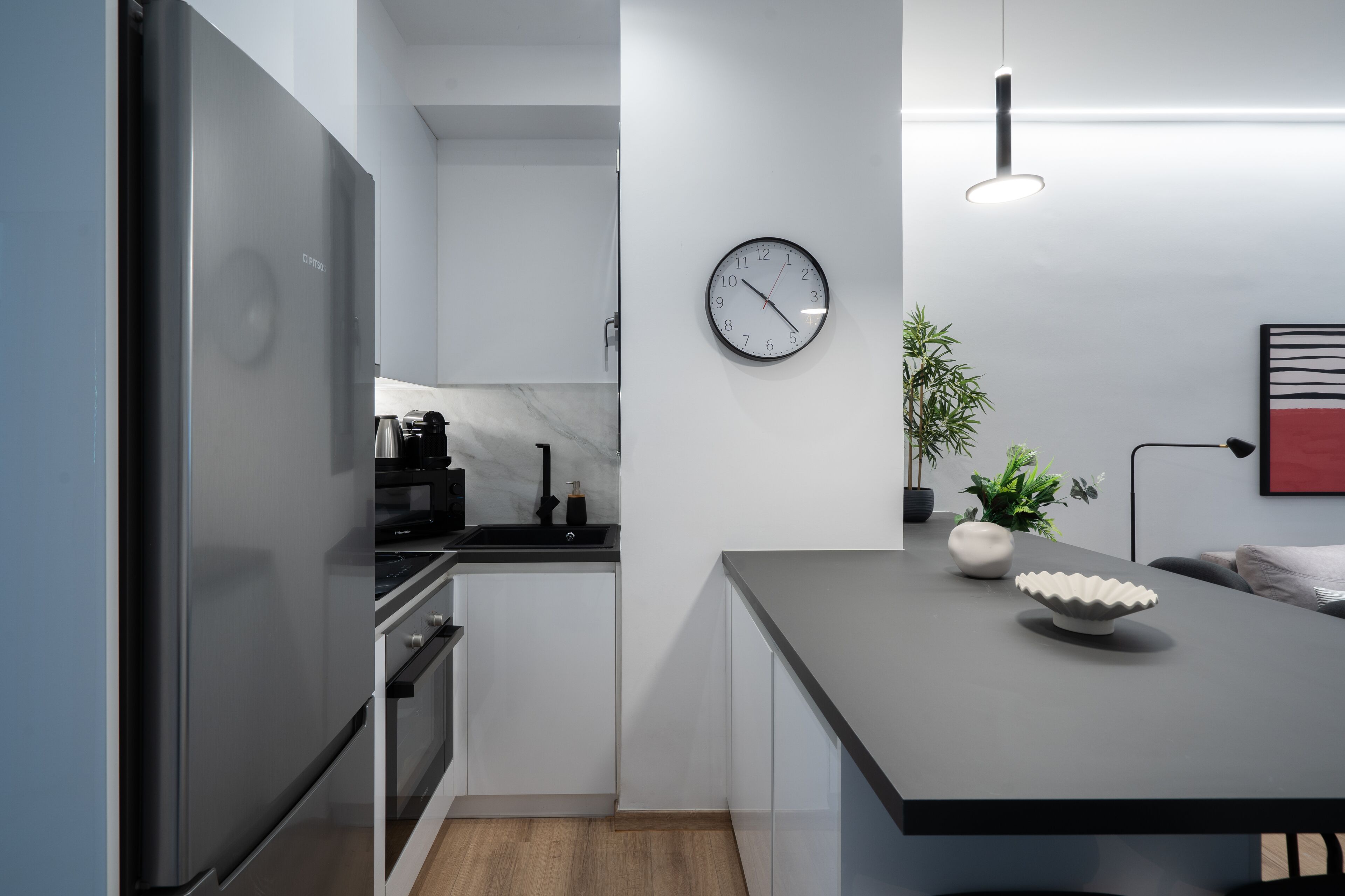 A modern kitchen with a stainless steel refrigerator, a microwave, and a coffee maker on the countertop.