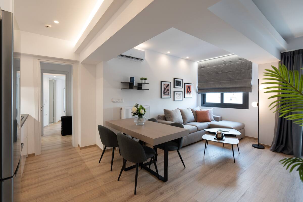Un salon moderne comprenant un coin repas, un canapé, une table basse et une grande fenêtre offrant une vue dégagée.
