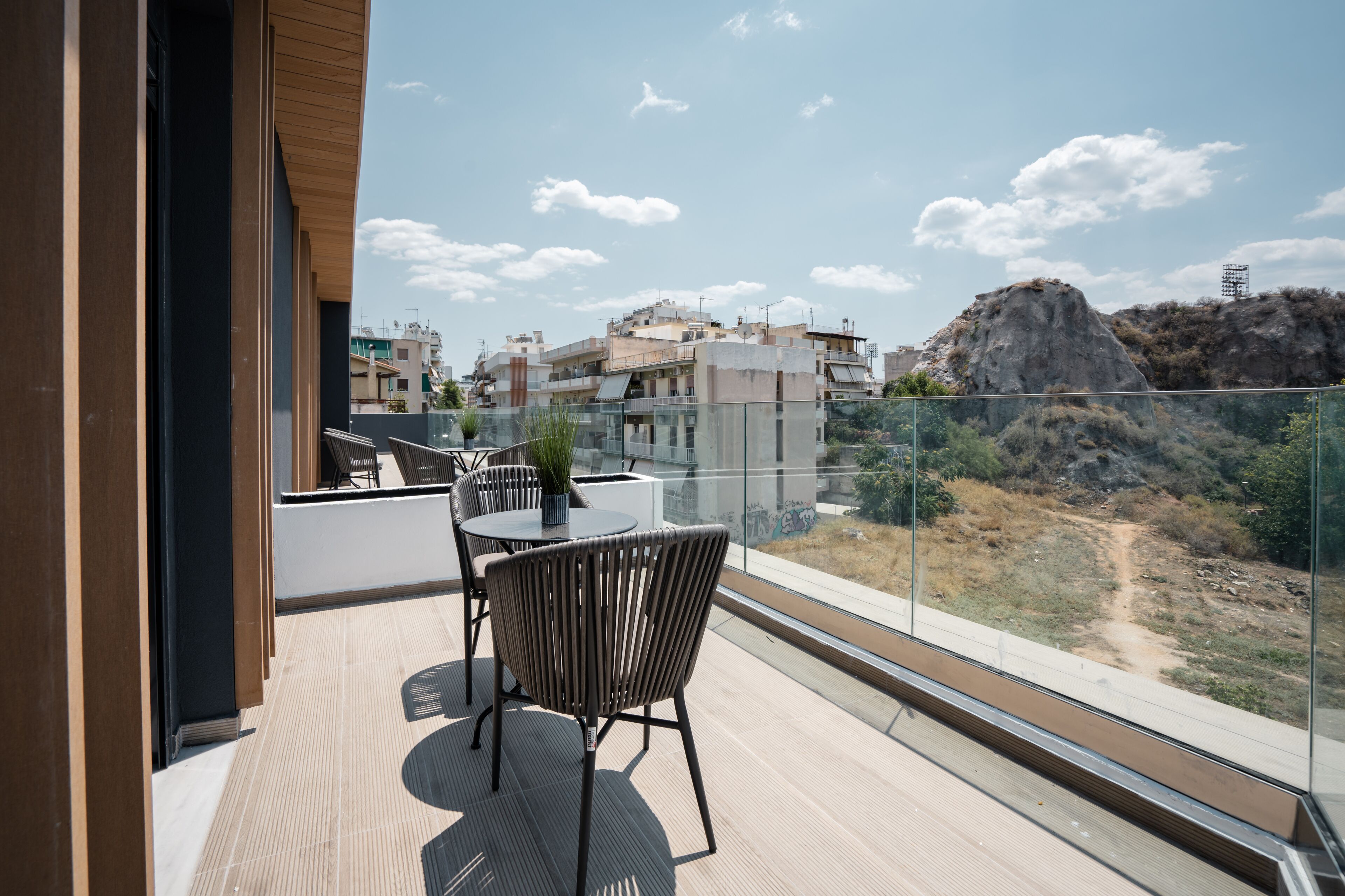 Un balcon donnant sur une colline rocheuse et des bâtiments.