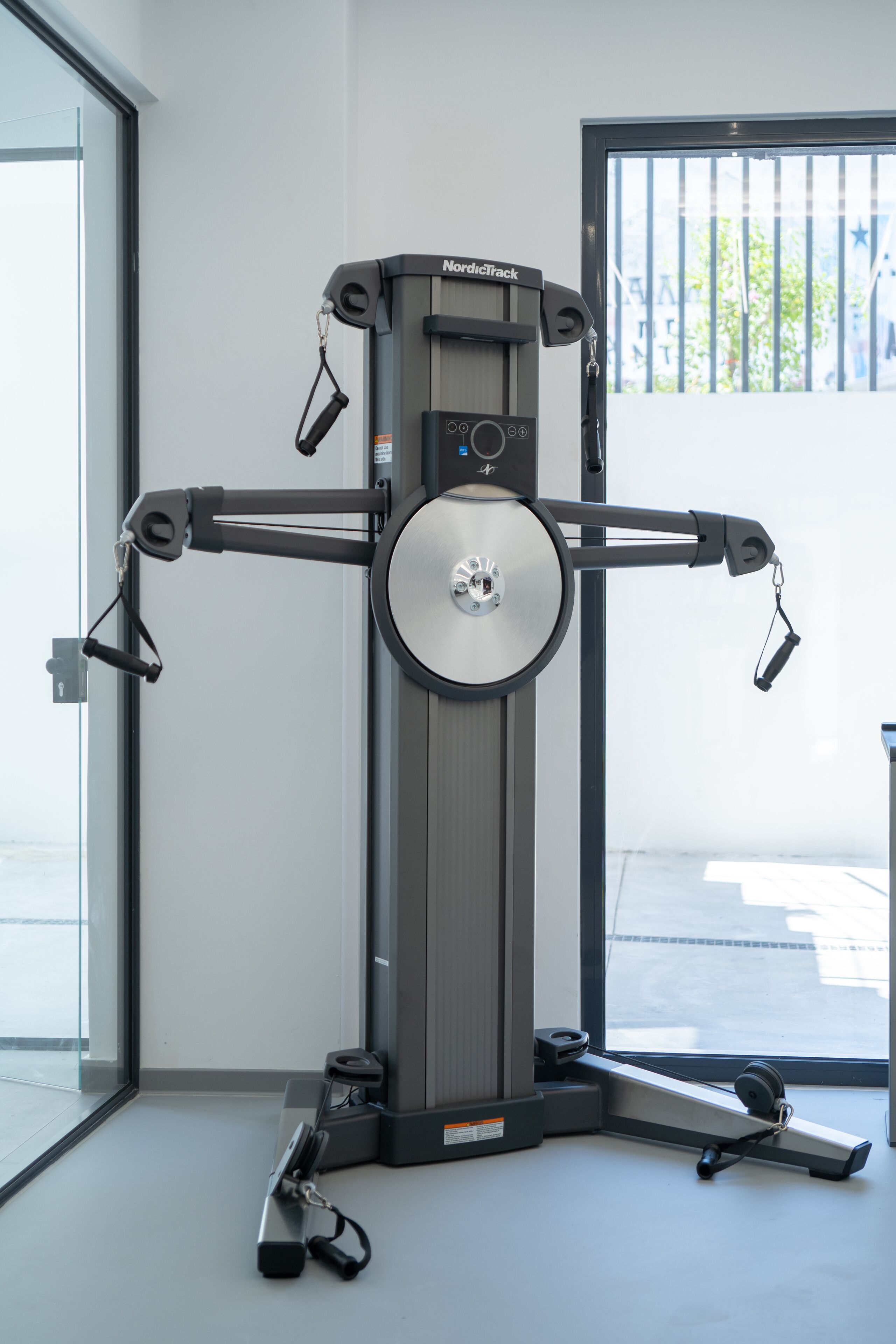 A NordicTrack exercise machine in a room with a large window.