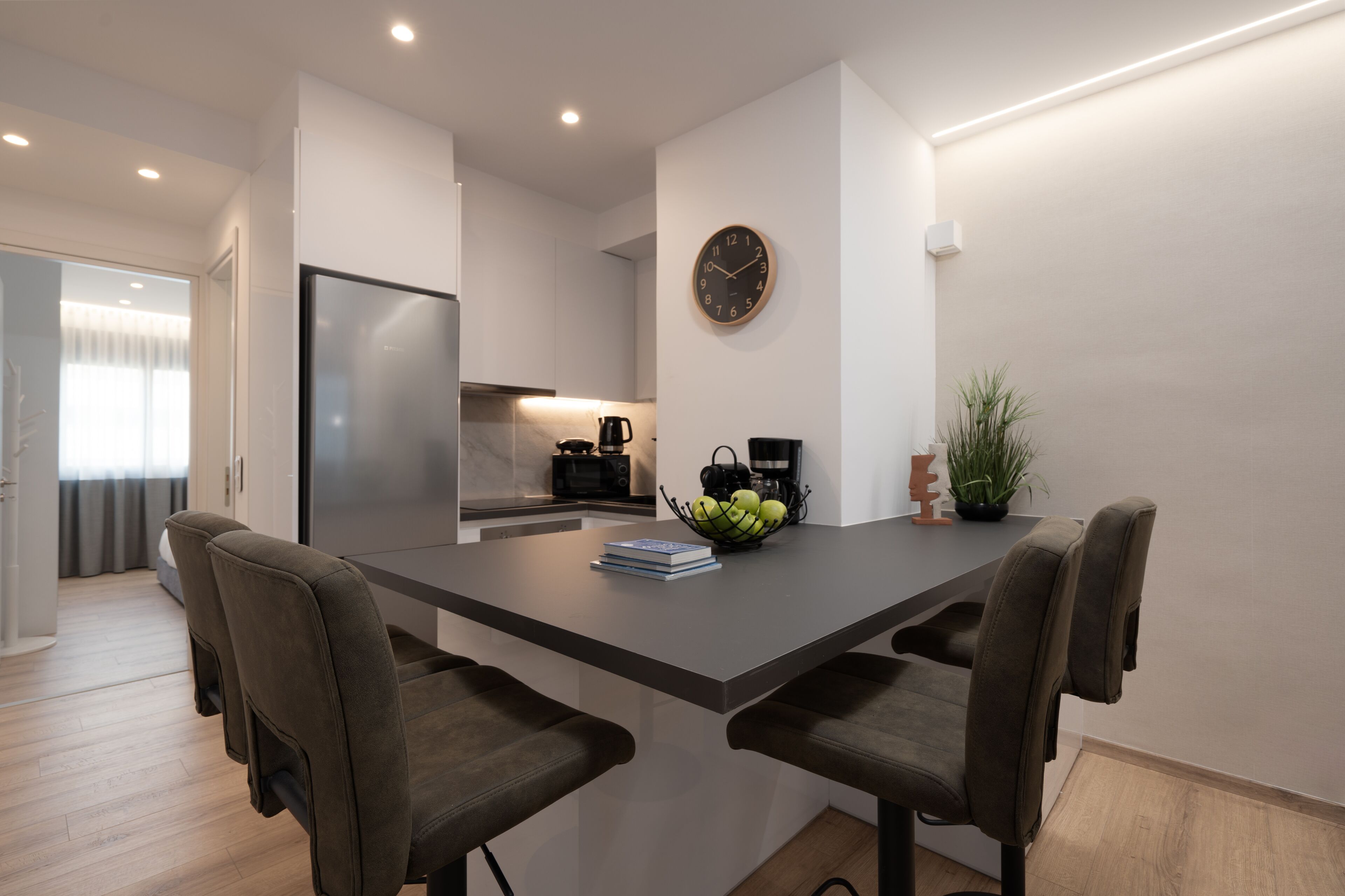 Cozinha moderna com ilha central, micro-ondas e cafeteira.