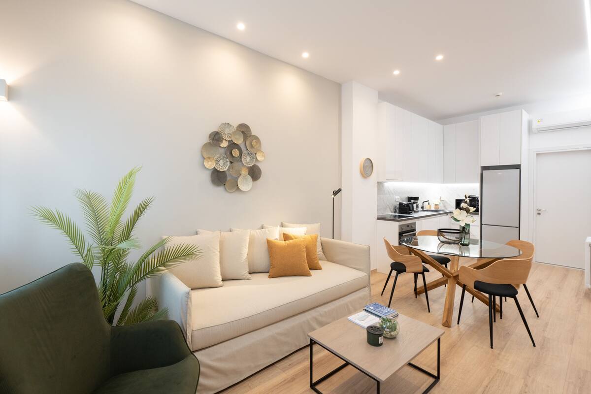 Un salon moderne avec un canapé, une table basse et un coin repas.