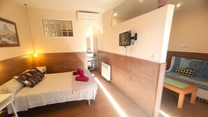 A hotel room with a bed, a small table, a TV, and a window with a view. - D-1 Studio with terrace and views (Malaga)