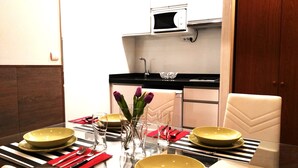 A dining area with a glass table set for four, featuring striped placemats and gold bowls. - D-1 Studio with terrace and views (Malaga)