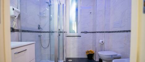 Une salle de bain moderne avec une douche à parois de verre, des toilettes et un lavabo.