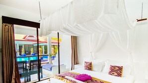 Une chambre spacieuse avec un grand lit, un ciel de lit blanc et une vue sur l’espace extérieur abritant une piscine.