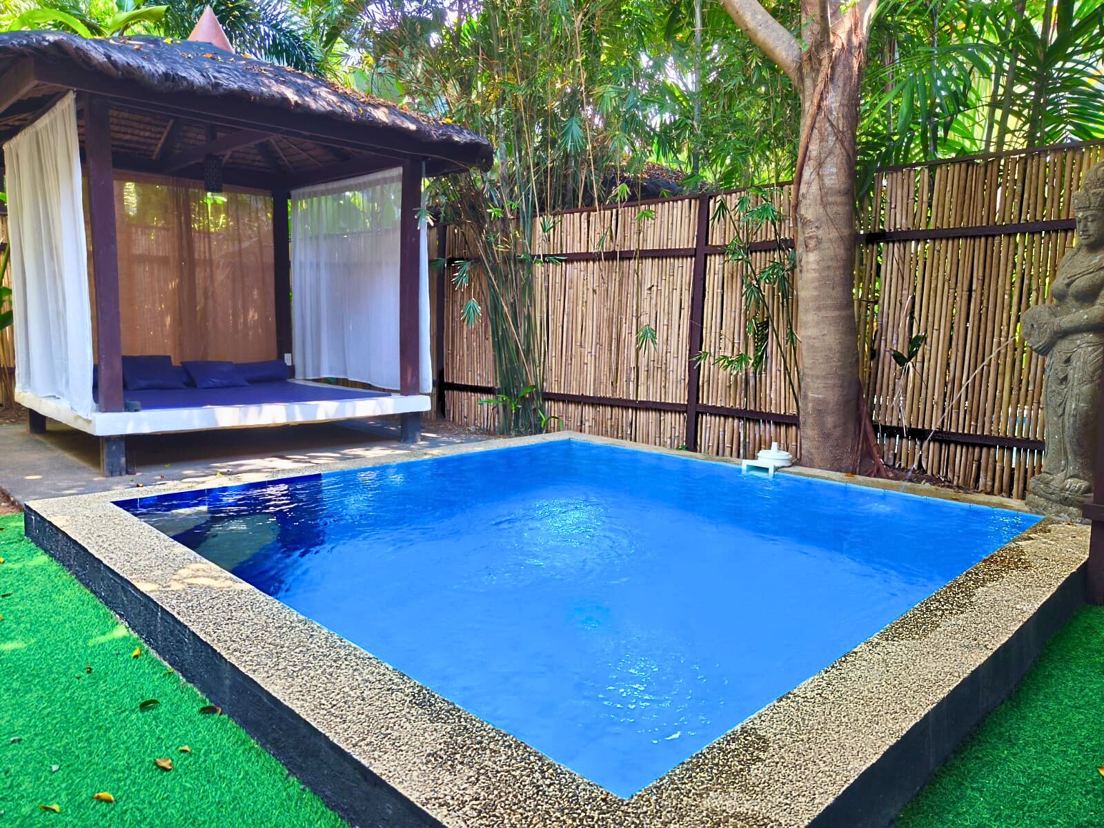 A rectangular swimming pool with a clear blue water surface, surrounded by a pebble border.