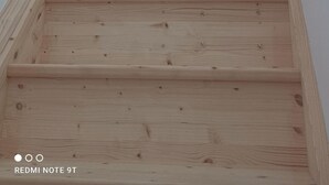 Een houten trap met een geometrisch patroon op de achtergrond.