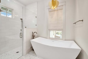 Bathtub, hair dryer, towels, toilet paper