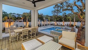 An outdoor patio area with a pool, lounge chairs, and a dining table.