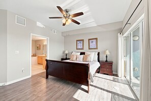 A bedroom with a bed, nightstands, a ceiling fan, and a view through a large window. - Penthouse condo with amazing views! Private 1000 sf balcony (Madeira Beach)