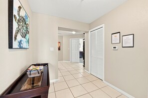A hallway with a wooden bench, a framed artwork, and a tiled floor. - Penthouse condo with amazing views! Private 1000 sf balcony (Madeira Beach)