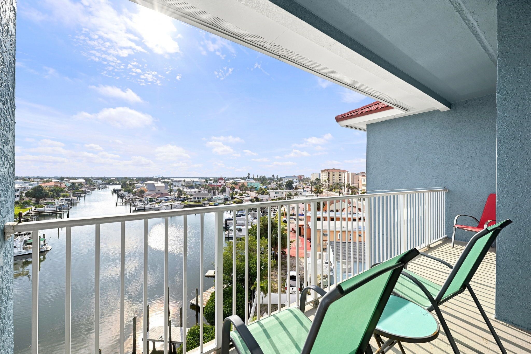 Un balcon avec vue sur un port de plaisance et sur le paysage urbain.