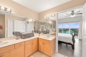 A modern bathroom with a large mirror, vanity, and a shower.