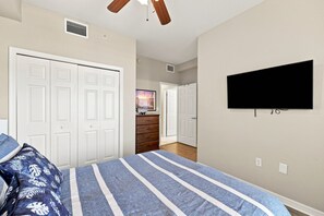 Quarto com cama, televisão, guarda-roupa e cômoda.