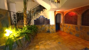 A spacious indoor area with a staircase, stone walls, and a tiled floor. - G-3 Studio with patio and mountain views. (Malaga)
