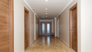 Un pasillo con puertas de madera, un extintor y un cartel sobre la puerta.