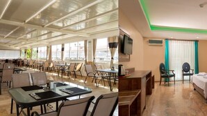 Un vestíbulo de hotel con una escalera, un comedor con mesas y sillas, y un dormitorio con cama y mesita de noche.