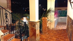 A staircase with a checkered pattern, leading to a balcony with a tiled floor and a brick pillar. - D-2 Apartment with a terrace. (Malaga)