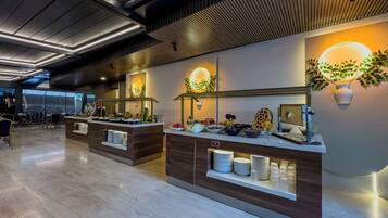 A modern buffet setup with multiple serving stations, each with a variety of food items and utensils.