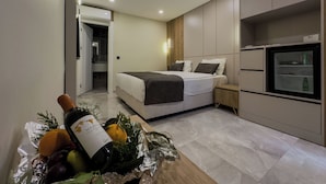 A modern hotel room with a bed, a minibar, and a kitchen area. - Quality Gold Suit Hotel (Antalya)