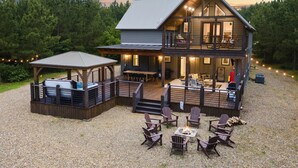 A two-story log cabin with a deck, outdoor seating area, and a fire pit. - Broken Bow Secluded Playset Retreat for Families (Broken Bow)