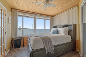 Enjoy a restful night's sleep with a view of the sea from this bedroom's large window.