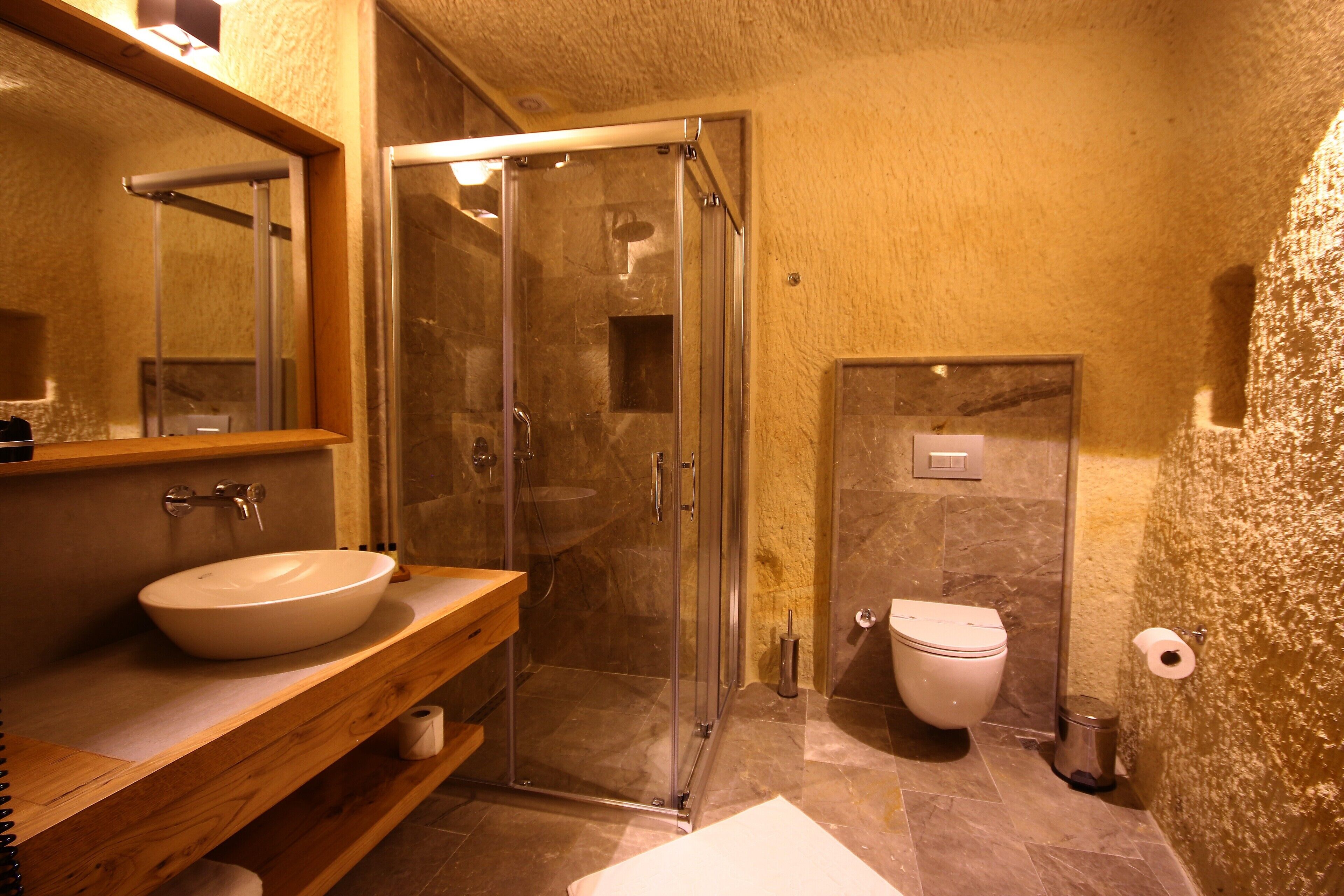 A bathroom with a glass-enclosed shower, a white sink, and a toilet.