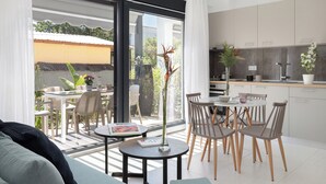 Een moderne keuken met een eethoek, grote ramen en uitzicht op de omgeving.