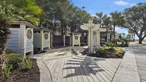 A wooden deck with a curved pathway leading to a gazebo, surrounded by lush greenery and trees. - The Cottages in Shipyard Golf Course & Lagoon Views private Beach Access! (Hilton Head Island)