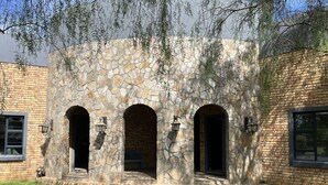 A stone building with three arched doorways and a brick exterior.