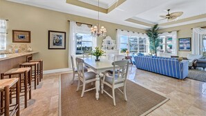 A spacious kitchen with a dining area, a bar, and a seating area with a view. - Stunning 3 Bedroom / 2.5 Bath Condo Steps from Siesta Key Beach! (Siesta Key)