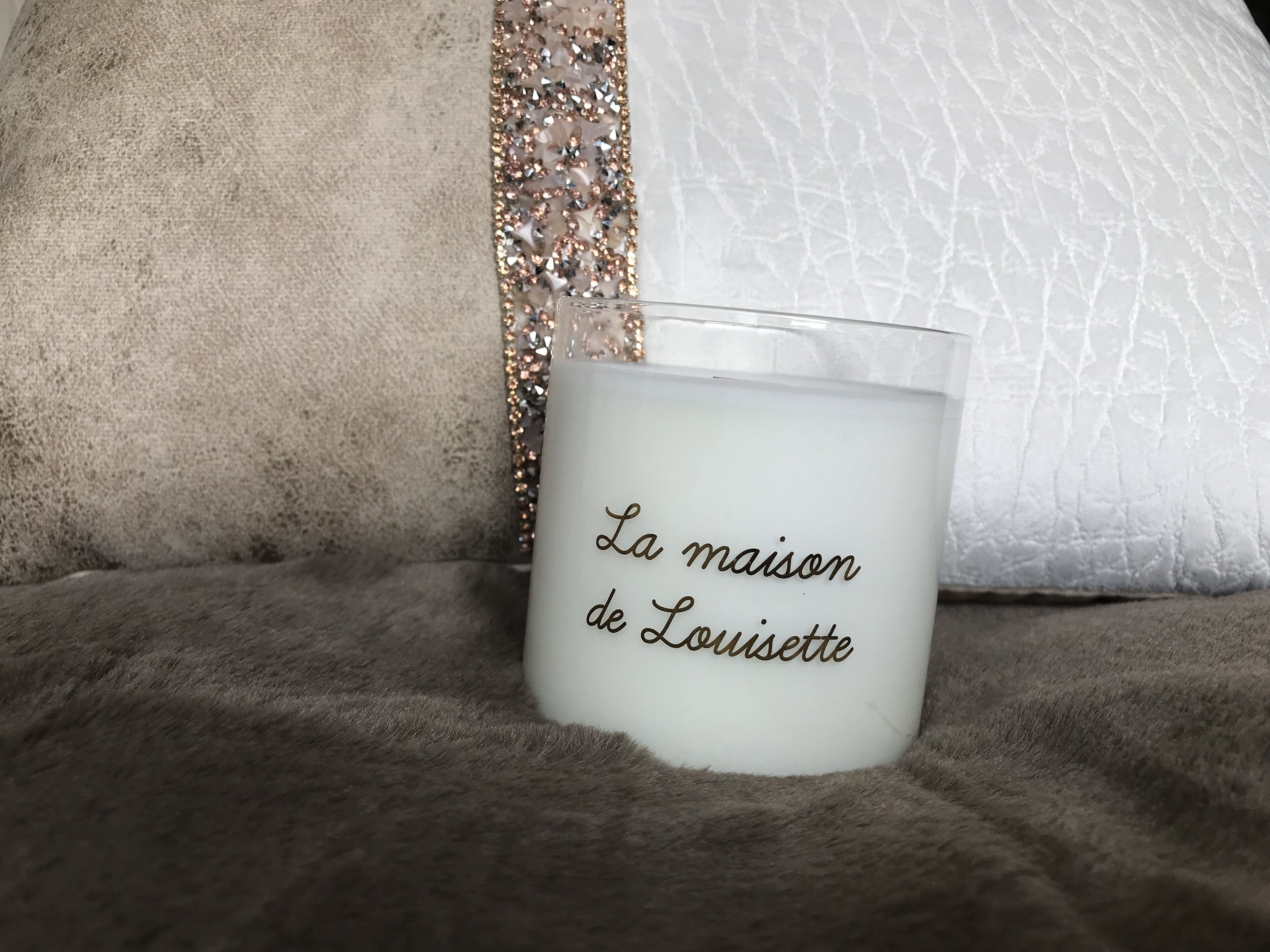 Une bougie portant une inscription, posée sur une surface texturée.