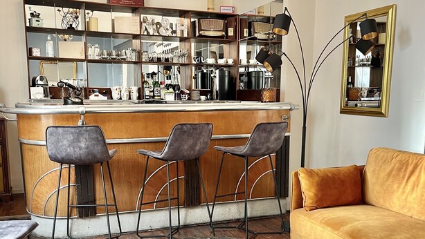 A modern living room with a bar area, featuring a sofa, chairs, a coffee table, and a patterned rug. - La maison de Louisette (Le Faouet)