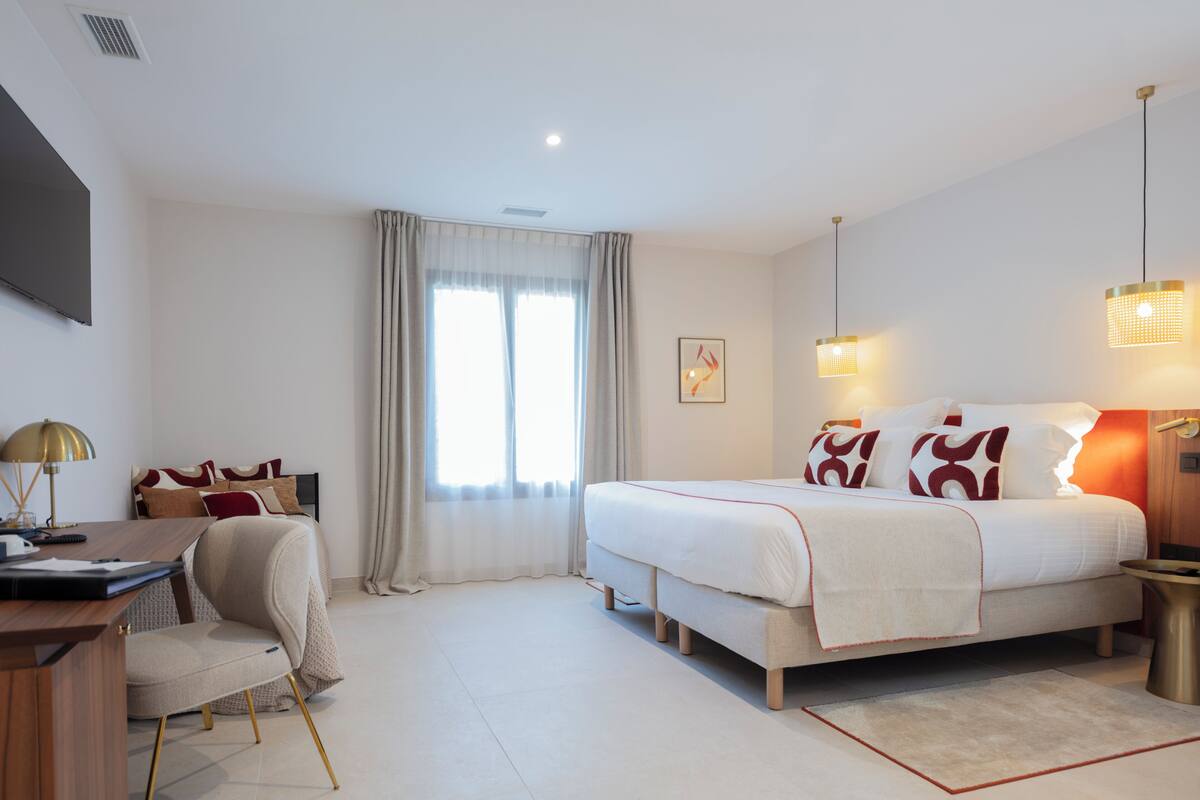 Ein modernes Hotelzimmer mit einem großen Bett, einem Schreibtisch und einem Stuhl.