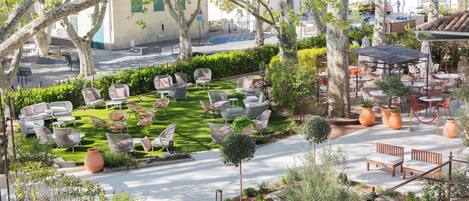 A courtyard with outdoor seating, a lawn, and a street view.