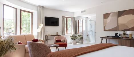 Una habitación de hotel moderna con una cama grande, un sofá, una silla, un escritorio y un televisor.