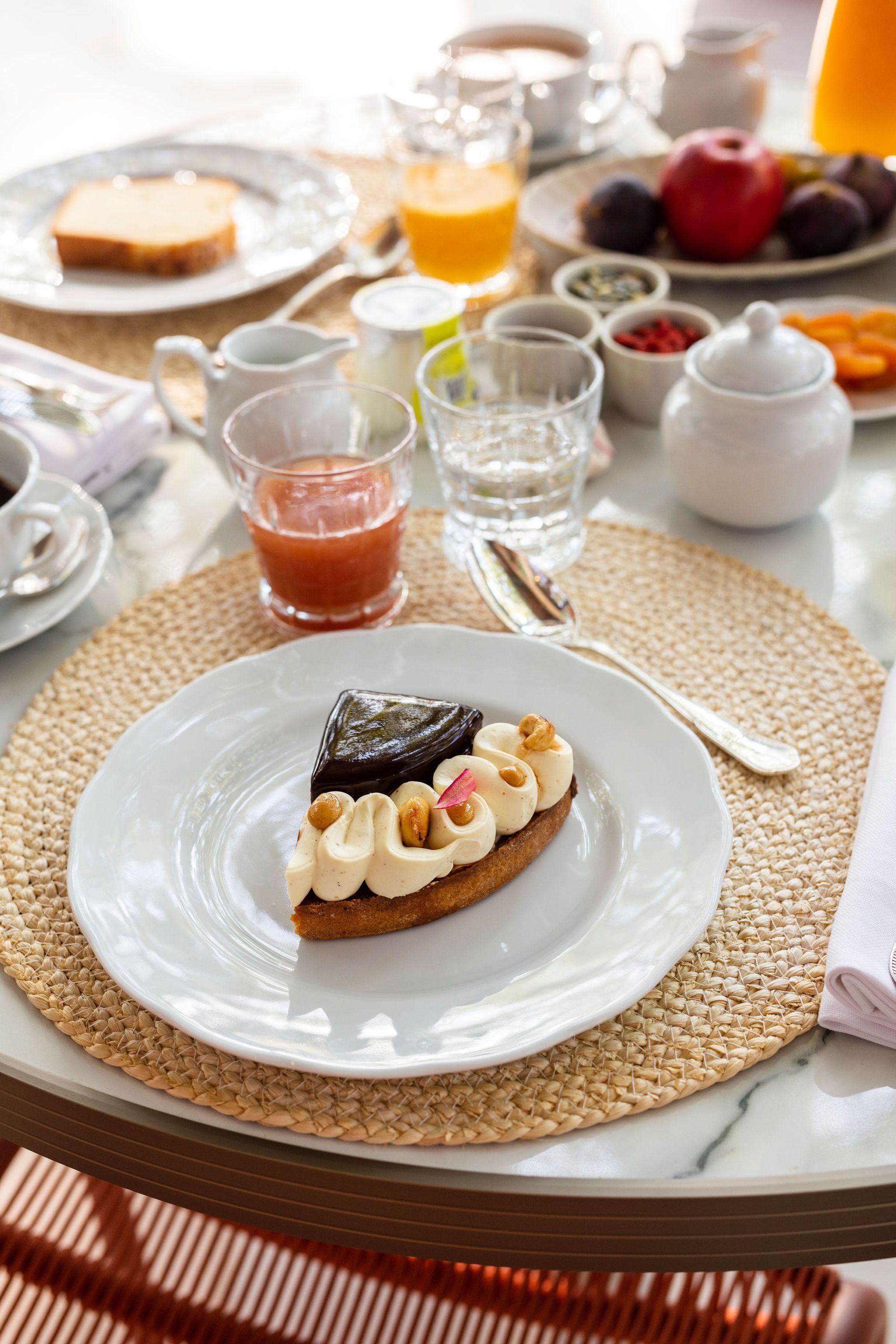 A breakfast setting with a plate of food, a jug of orange juice, and various condiments on a table.