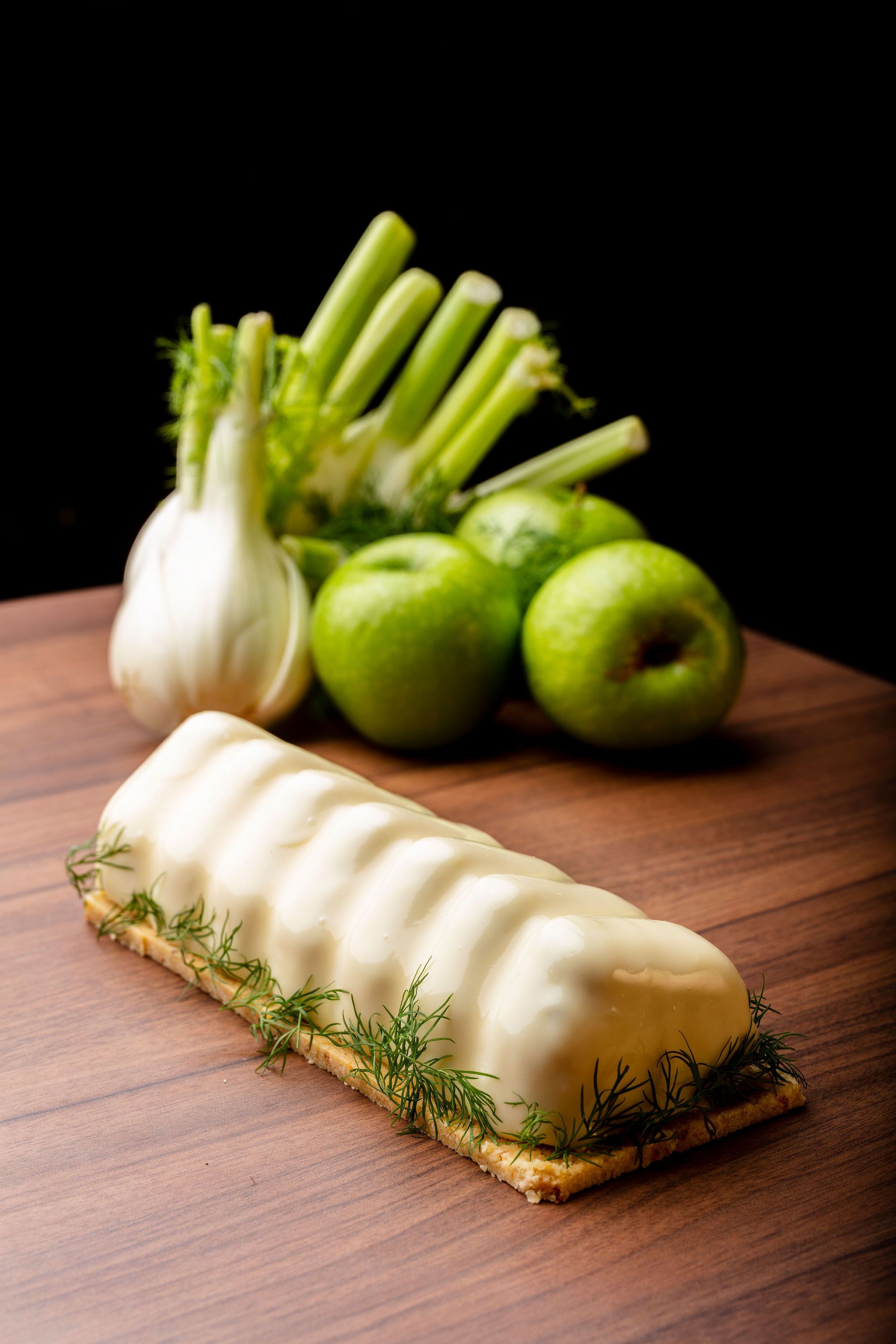A wooden table with a white object, possibly a food item, garnished with green herbs.